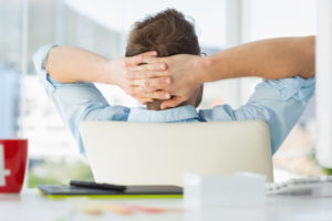Handsome designer relaxing at his desk in creative office